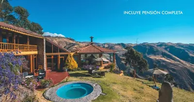 a house with a swimming pool in front of a mountain at Refugio Viñak in Viñak