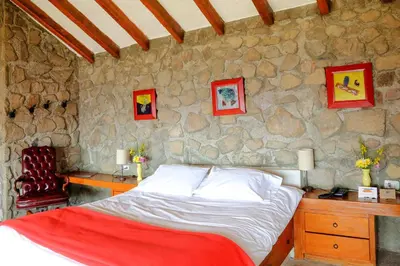 a bedroom with a bed and a stone wall at Refugio Viñak in Viñak