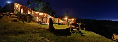 a house on the side of a hill at night at Refugio Viñak in Viñak