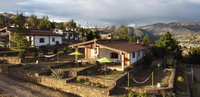 a small house with yellow umbrellas in a village at Tuki Llajta - Pueblo bonito Lodge in Huancayo