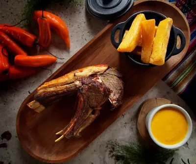 a cutting board with a piece of meat and french fries at Tuki Llajta - Pueblo bonito Lodge in Huancayo
