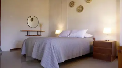 a bedroom with a bed and a mirror on the wall at Tuki Llajta - Pueblo bonito Lodge in Huancayo