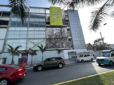 a parking lot with cars parked in front of a building at Bright 1BR close to boulevard in Lima