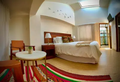 a bedroom with a bed and a table and chairs at Inkantari Boutique Hotel in Cusco