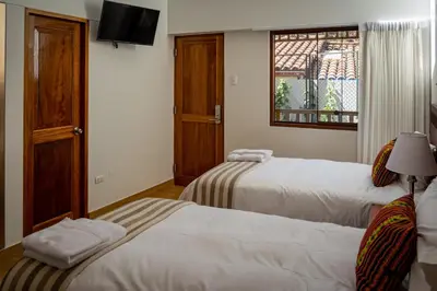 a hotel room with two beds and a window at Inkantari Boutique Hotel in Cusco