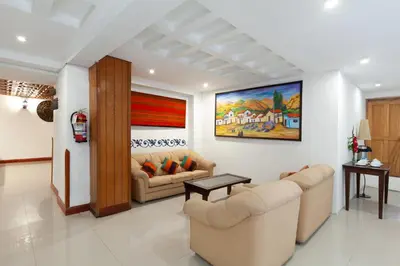 a living room with couches and a painting on the wall at Hotel Amerinka in Cusco