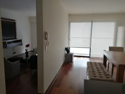 a living room with a couch and a table and a window at EL PRAT Luxury Aparment Lima Peru in Lima