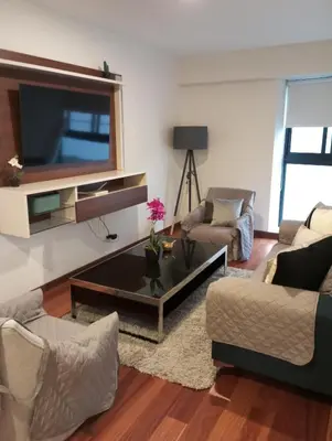 a living room with a flat screen tv on a wall at EL PRAT Luxury Aparment Lima Peru in Lima
