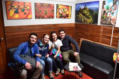 a group of people sitting on a couch in a room at Carlos Guest House 1 Cusco in Cusco