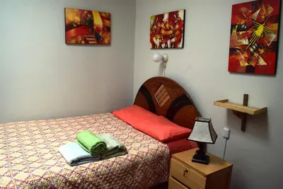 a bedroom with a bed and a lamp on a night stand at Carlos Guest House 1 Cusco in Cusco