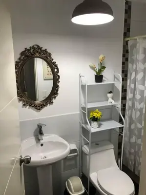 a bathroom with a sink and a toilet and a mirror at Lindo Departamento en Av. Guardia Civil 861 - Chorrillos in Lima