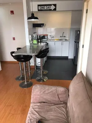 a kitchen with a couch and a table in a room at Lindo Departamento en Av. Guardia Civil 861 - Chorrillos in Lima
