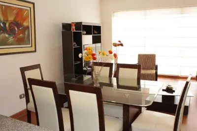 a dining room with a glass table and chairs at New and nice apartment Miraflores in Lima