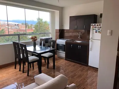 a kitchen with a table and chairs and a kitchen with a window at Departamento en el centro histórico en 3er y 4to piso in Ayacucho