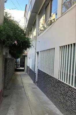 an empty alleyway next to a white building at Departamento en el centro histórico en 3er y 4to piso in Ayacucho