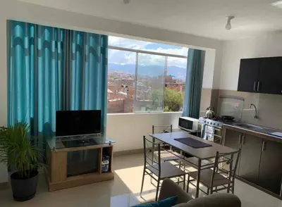 a living room with a table and a large window at Departamento en el centro histórico en 3er y 4to piso in Ayacucho