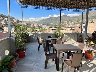 a patio with tables and chairs and a view of a city at Departamento en el centro histórico en 3er y 4to piso in Ayacucho