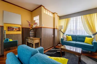 a living room with blue furniture and yellow walls at Lima Virreinal & primer piso muy acogedor in Lima