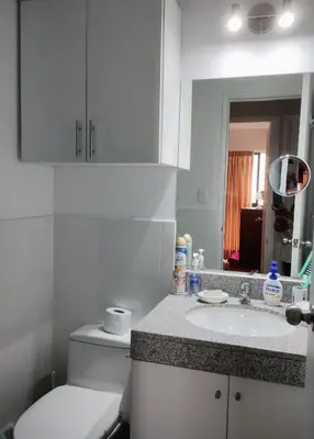 a bathroom with a toilet and a sink and a mirror at Confortable habitación baño privado desayuno opcional in Lima