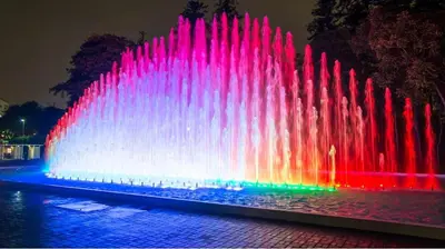 a fountain with colored lights in a park at night at Confortable habitación baño privado desayuno opcional in Lima