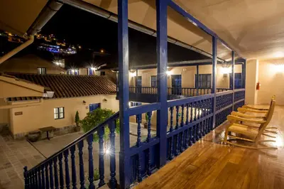 a balcony with a blue railing and two wooden chairs at Tierra Viva Cusco San Blas in Cusco