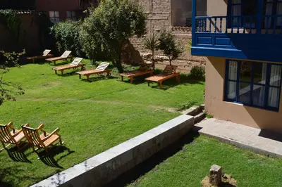 a group of benches sitting in the grass next to a building at Tierra Viva Cusco San Blas in Cusco