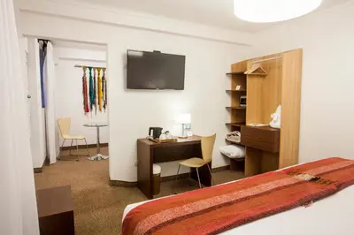 a hotel room with a bed and a desk with a computer at Tierra Viva Cusco San Blas in Cusco