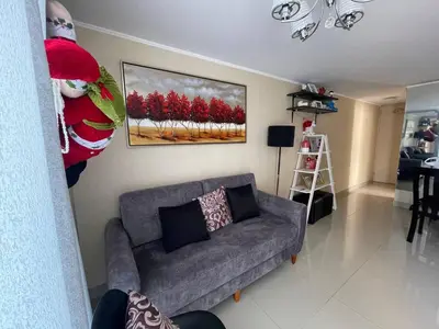a living room with a couch and a painting on the wall at Lindo y Acogedor Departamento en Lima! in Lima