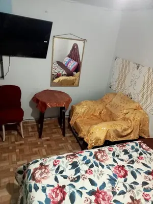 a room with two beds and a tv and a mirror at Posada Ternura in Lima