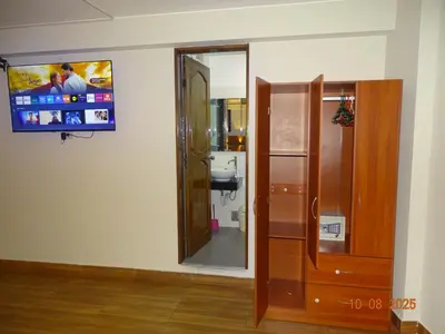 a bathroom with a toilet and a television on the wall at Hospedaje Dimar Inn in Lima