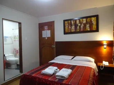 a bedroom with a bed with towels on it at Hospedaje Dimar Inn in Lima
