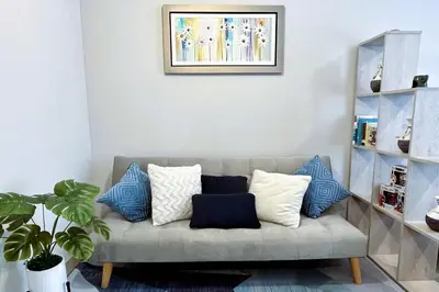 a living room with a couch with blue and white pillows at Loft céntrico San borja - San Isidro in Lima