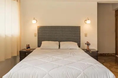 a bedroom with a large white bed with two night stands at Sueños del Valle Sagrado in Urubamba