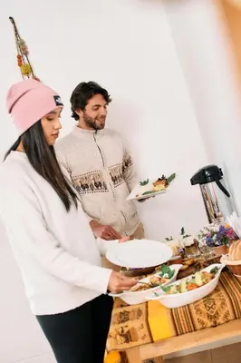 a man and woman standing in front of a table with food at Sueños del Valle Sagrado in Urubamba