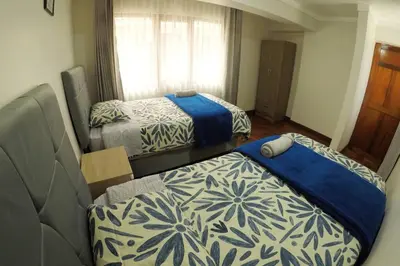 a bedroom with two beds and a couch and a window at Centric & cozy apartment with Garage in Cusco