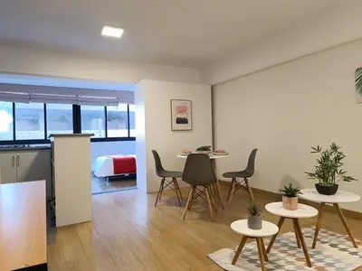 a living room with two tables and chairs and a bed at Runawasi Loft - Raywa 1 BDR, Centric and confortable. in Lima