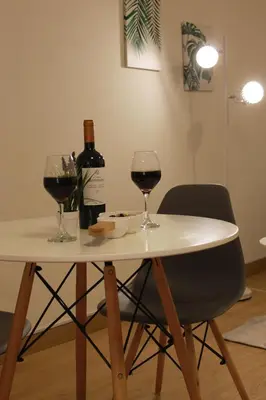 a white table with two glasses and a bottle of wine at Runawasi Loft - Raywa 1 BDR, Centric and confortable. in Lima