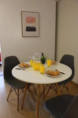 a white table with plates of food and glasses of orange juice at Runawasi Loft - Raywa 1 BDR, Centric and confortable. in Lima