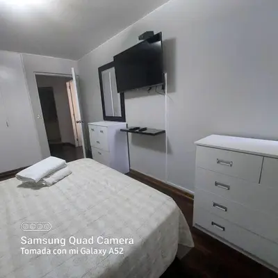 a bedroom with a bed and a dresser and a tv at APARTAMENTO 502 in Lima