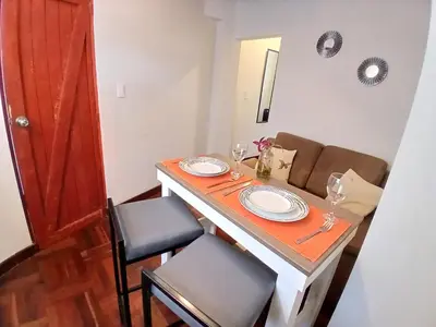 a dining room table with two chairs and a table with glasses at Centric, private, petfriendly budget apartments in Miraflores in Lima