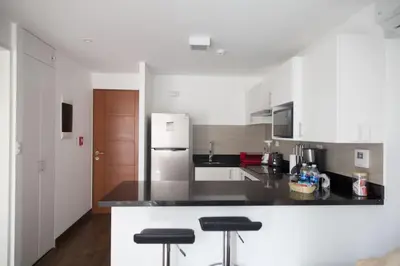 a kitchen with white cabinets and black counter tops at Barranco Perfect Location - Apartament in Lima