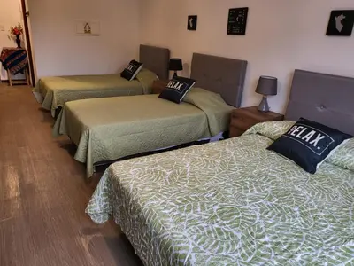 a room with three beds in a room at Alojamiento San Francisco - Apartamentos y habitaciones in Lima