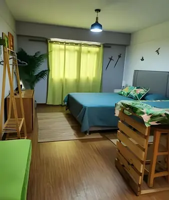 a bedroom with two beds and a table and a yellow curtain at Alojamiento San Francisco - Apartamentos y habitaciones in Lima