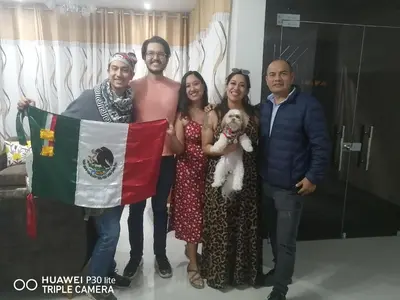 a group of people posing for a picture with a flag at LA FAMILIA NASCA HOUSE in Nazca