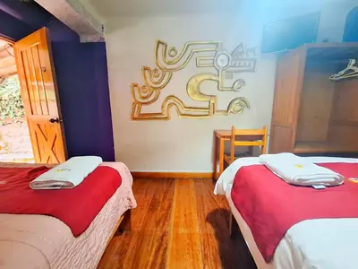 a room with two beds and a sign on the wall at Andenes del Sol in Cusco