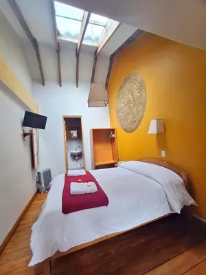 a bedroom with a large white bed with a red blanket at Andenes del Sol in Cusco