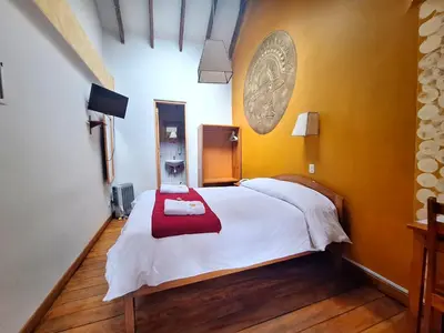 a bedroom with a white bed with a red blanket at Andenes del Sol in Cusco