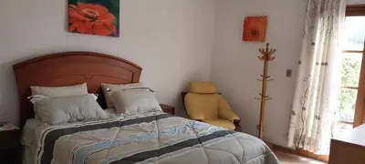 a bedroom with a bed and a yellow chair at Las buganvilias in Pachacamac