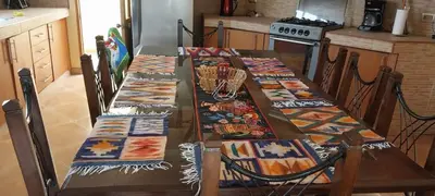 a table with four chairs with colorful blankets on it at Las buganvilias in Pachacamac