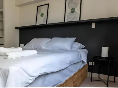 a large bed with white sheets and a black headboard at Cozy 2BR Loft in the Heart of Miraflores in Lima
